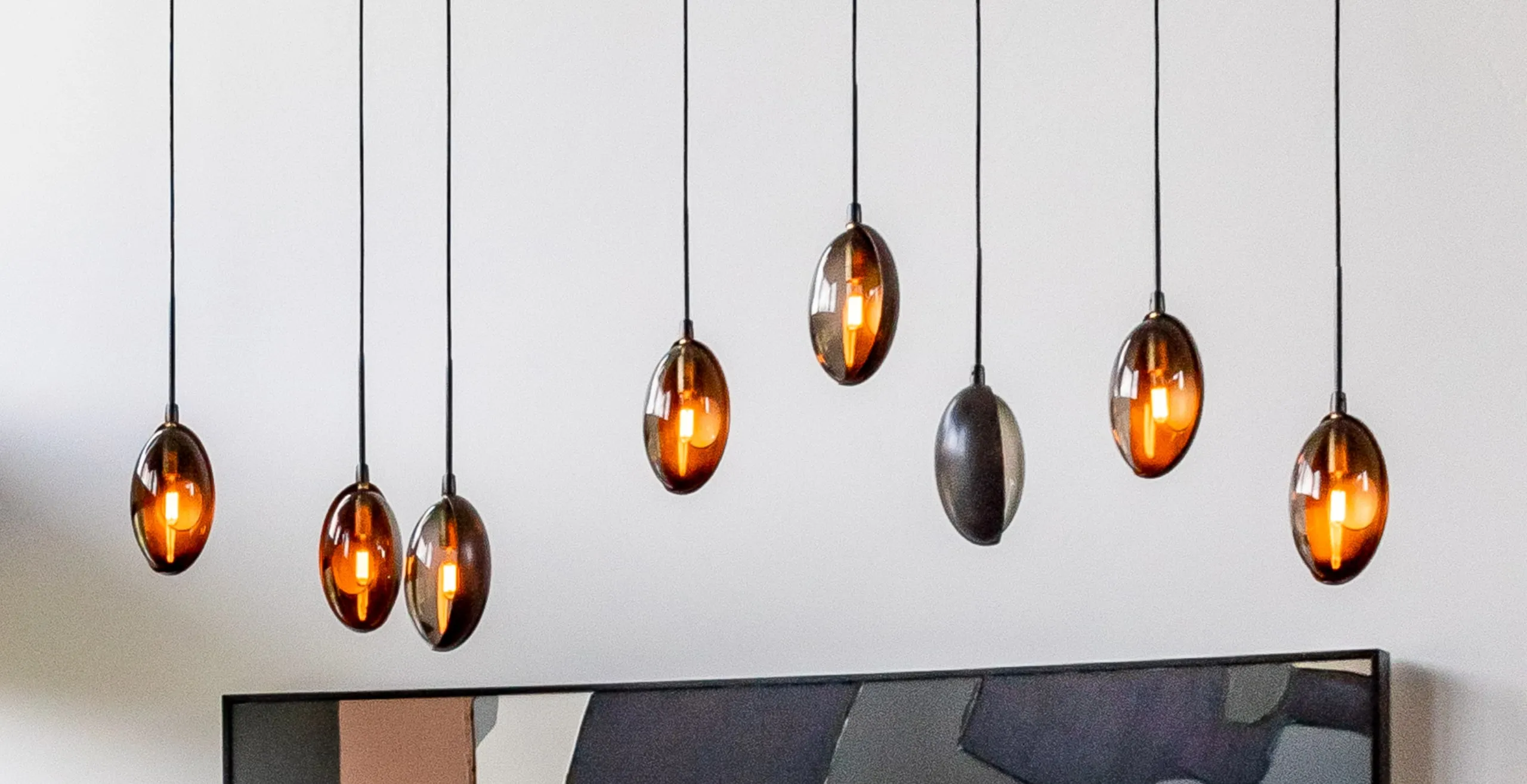 Oona pendants hung at staggered heights above a painting
