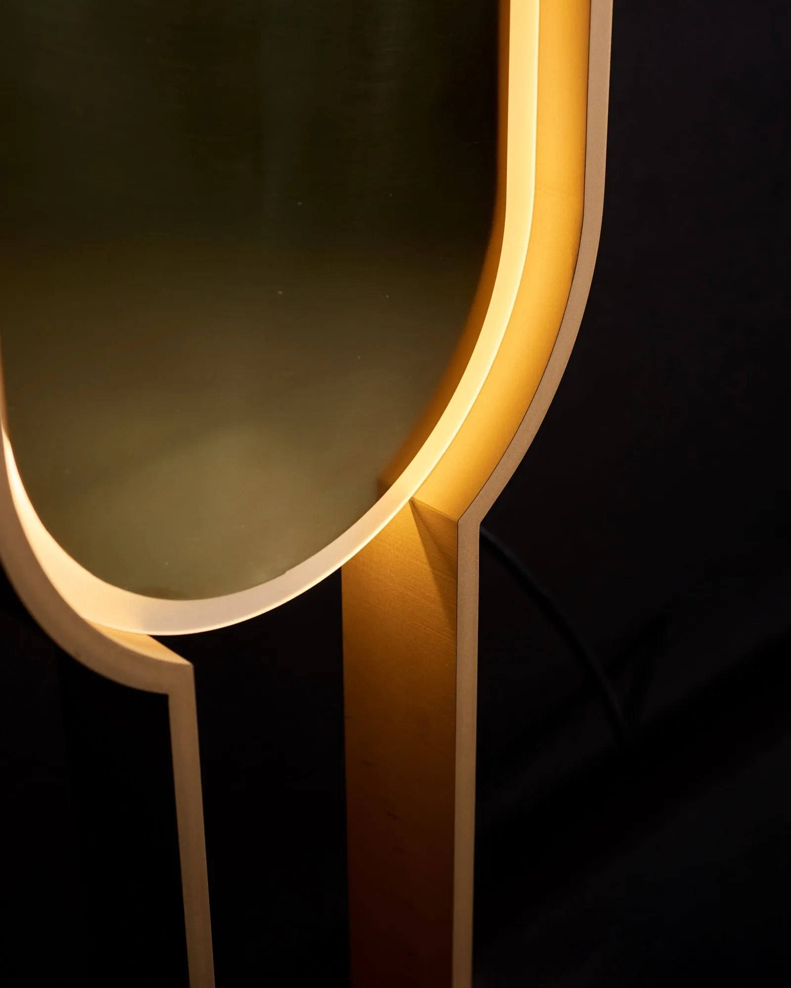 Close view of Portal Floor Lamp's brass curve, lit from within