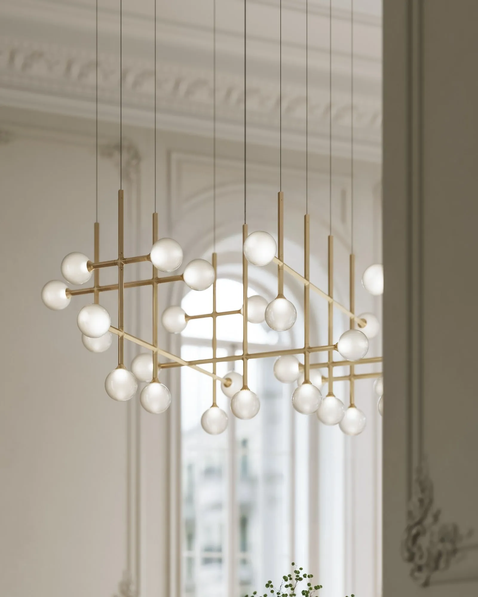 JUNIP pendants in Satin Brass hung in front of an arched window