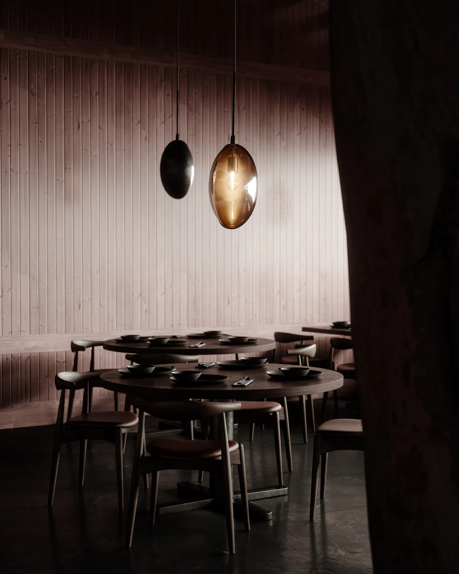 Two Oona pendants above a dining table in a dark, timber-walled restaurant