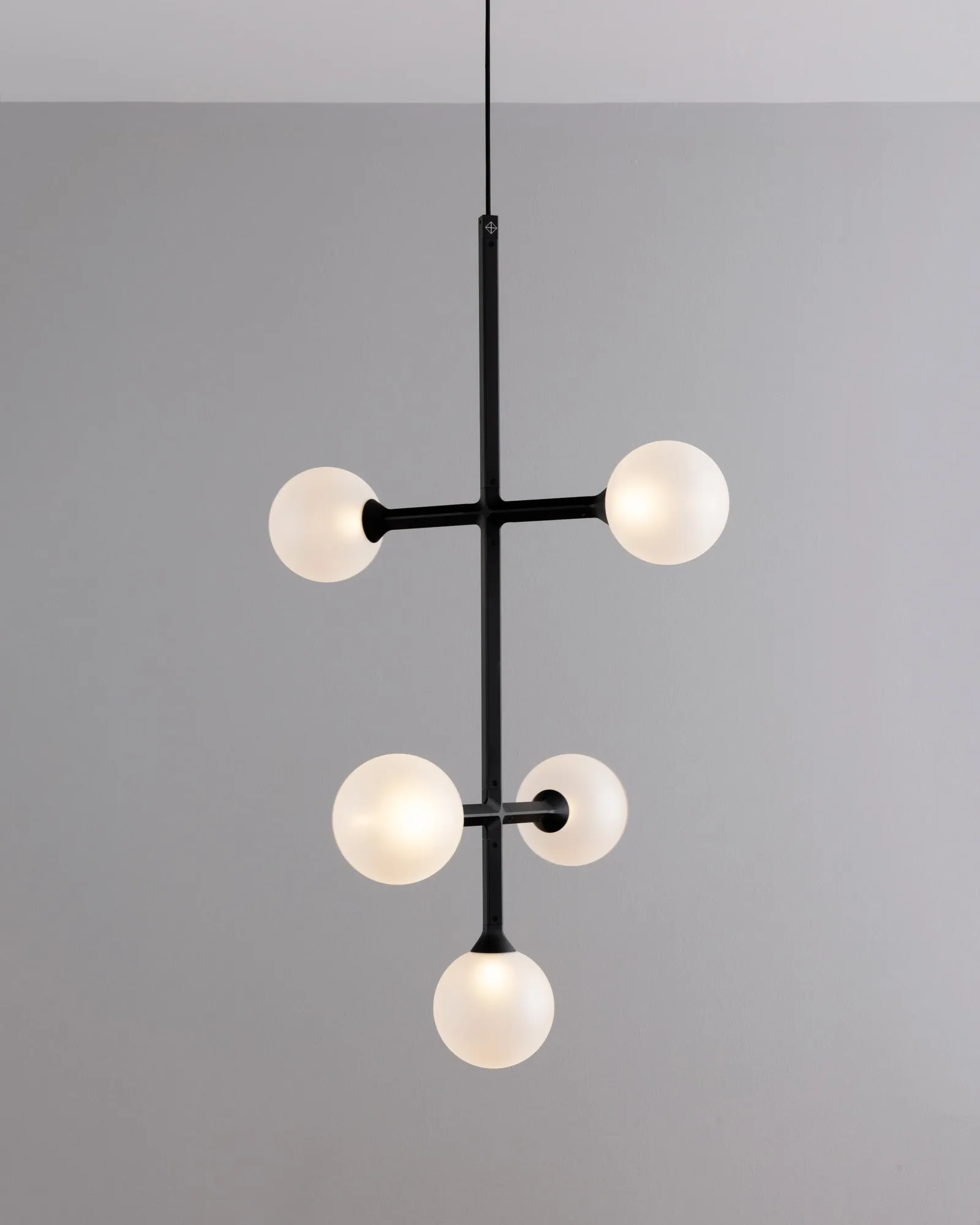 A JUNIP pendant in the studio with two crossbars of globes that turn on the stem