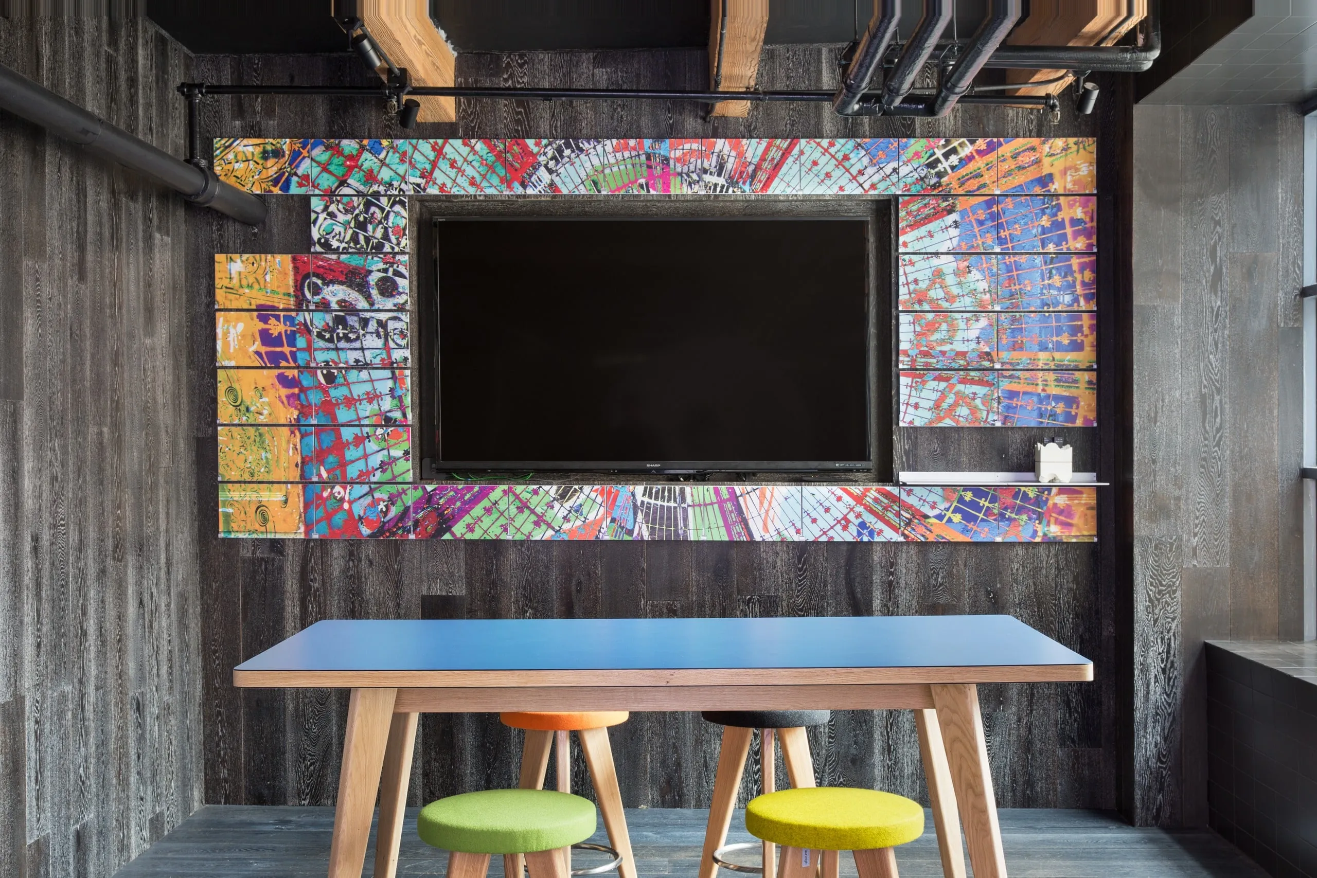 Riveli Art Shelves around a screen in a meeting room, printed in black and white, changing to color on hover