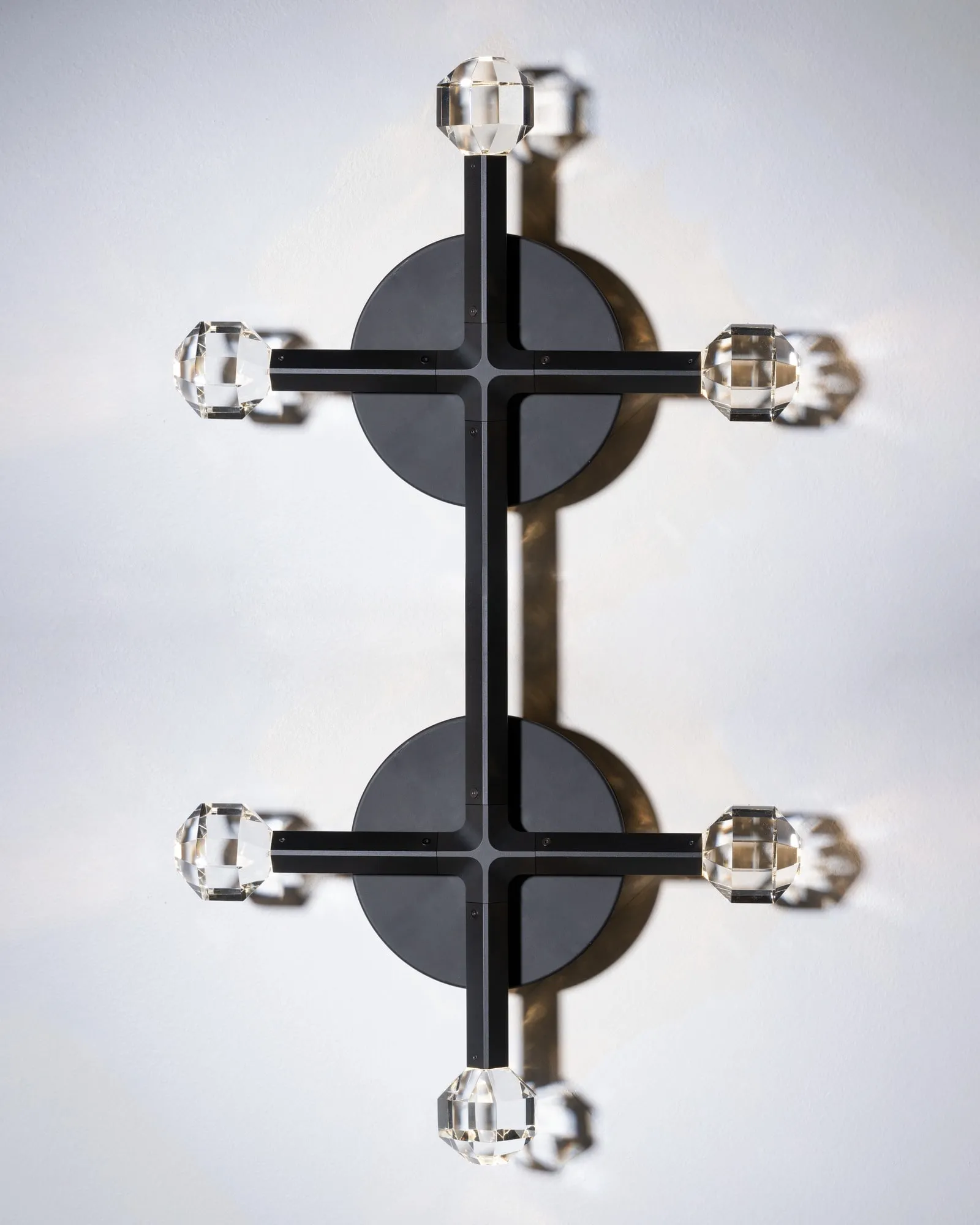 A JOULLE wall sconce with four crystal stones on a white wall