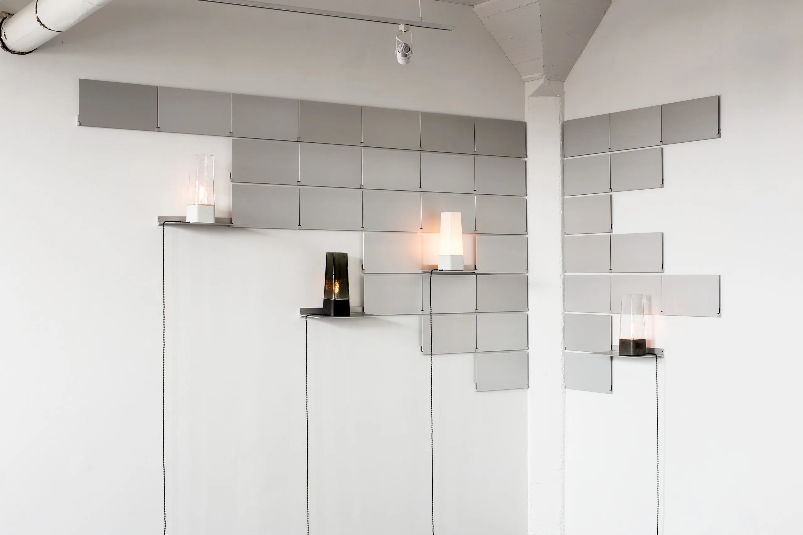 Faaro lamps lit on white shelves in a bright room