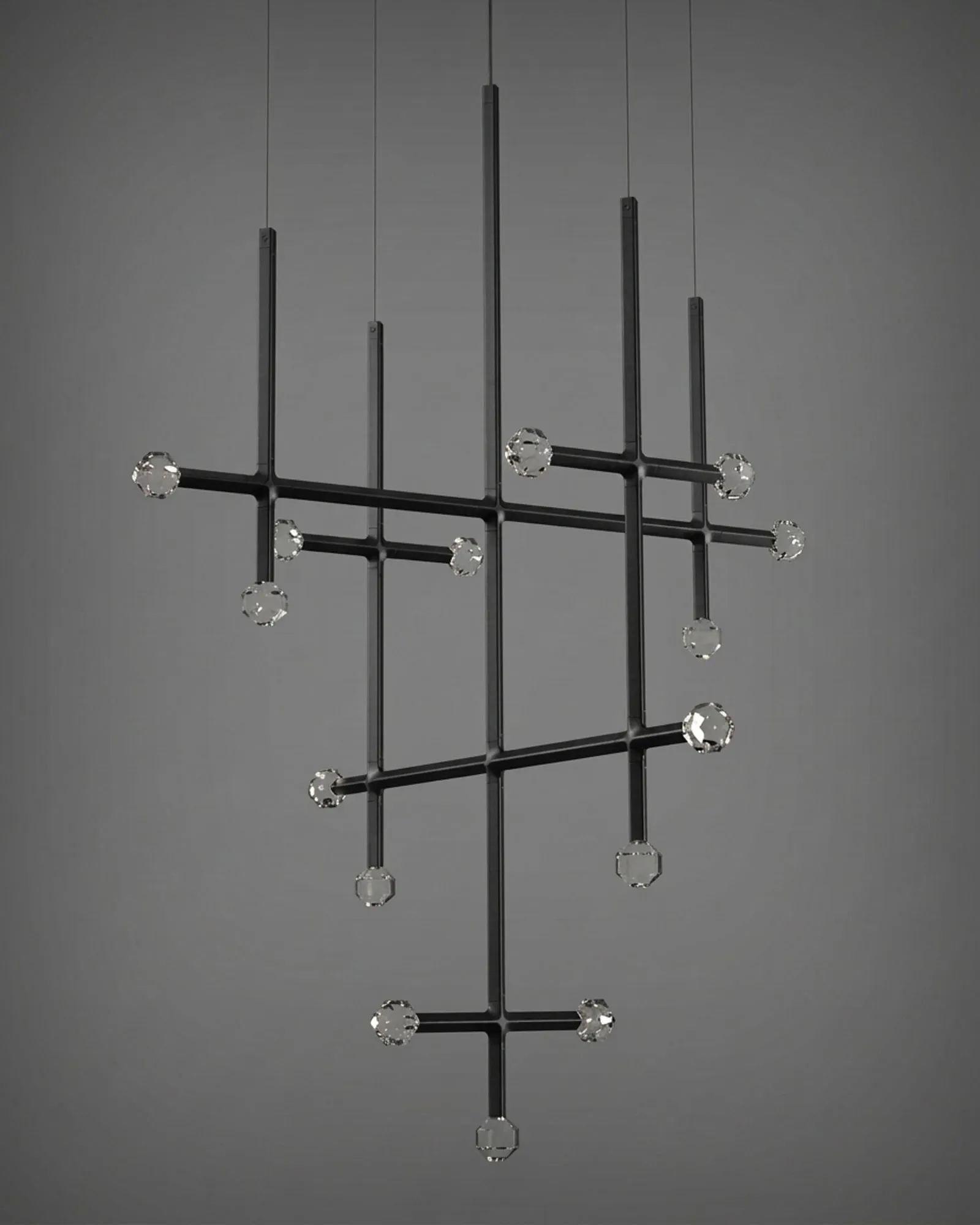 A JOULLE chandelier of several stems and crossing arms tipped with crystal stones, against a grey wall