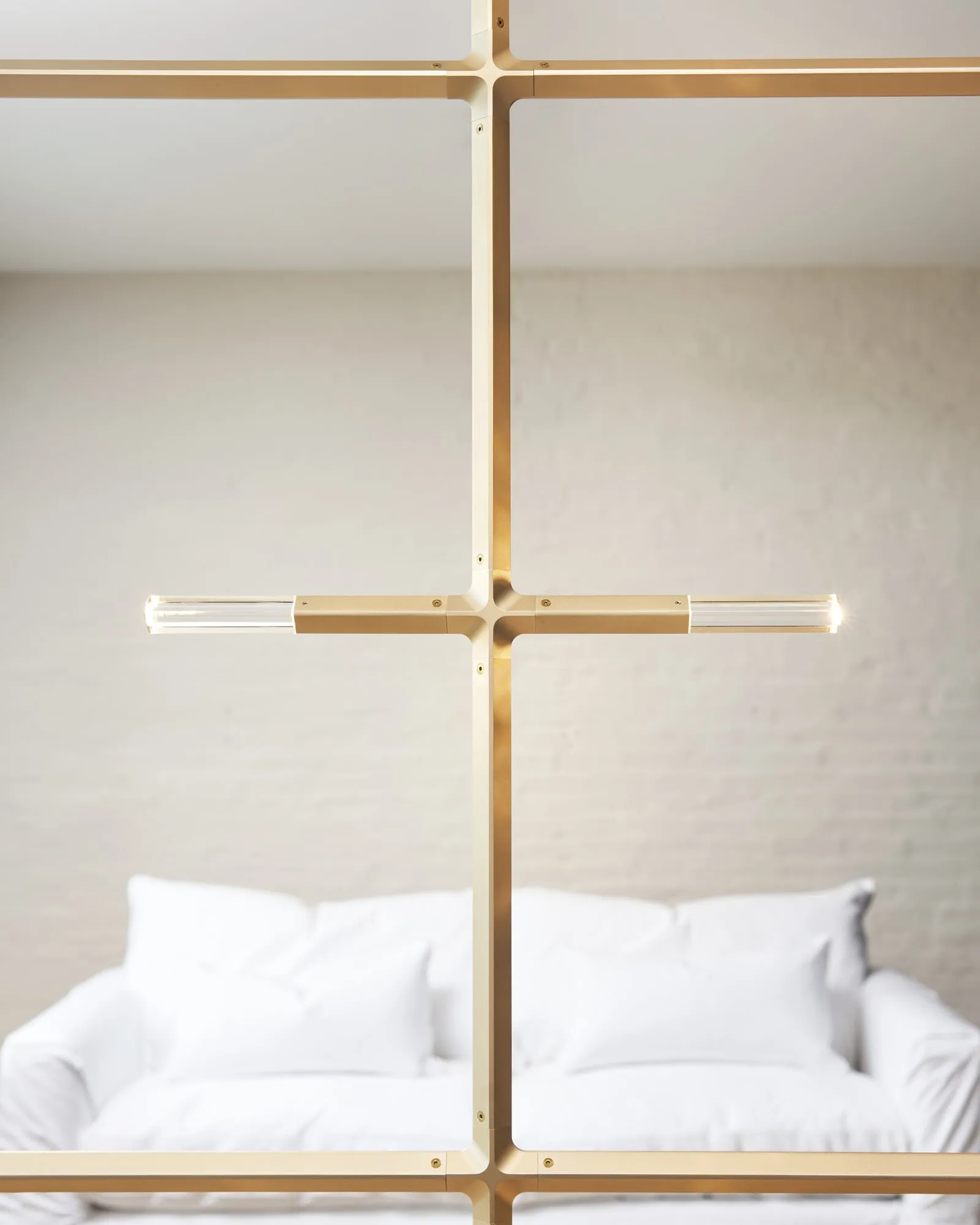 A JAX fixture in Satin Brass above a white sofa