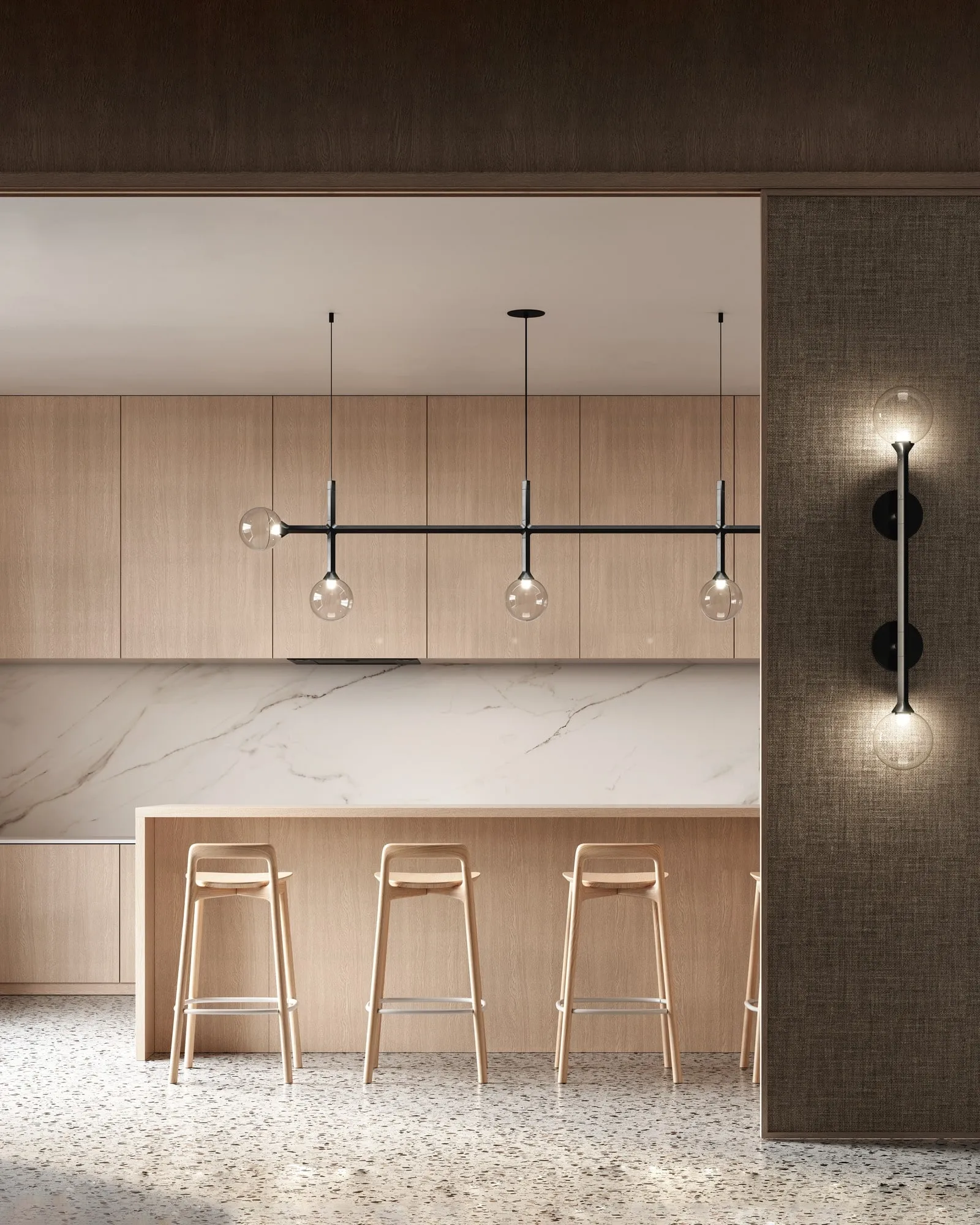 A JUNIP linear pendant over a marble kitchen counter, with a JUNIP sconce on a tiled wall