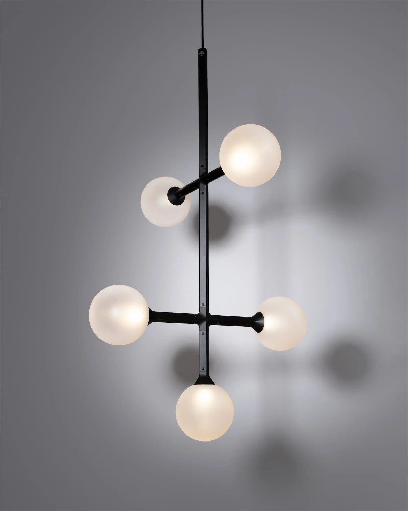 A JUNIP pendant in the studio with globes on arms at different heights