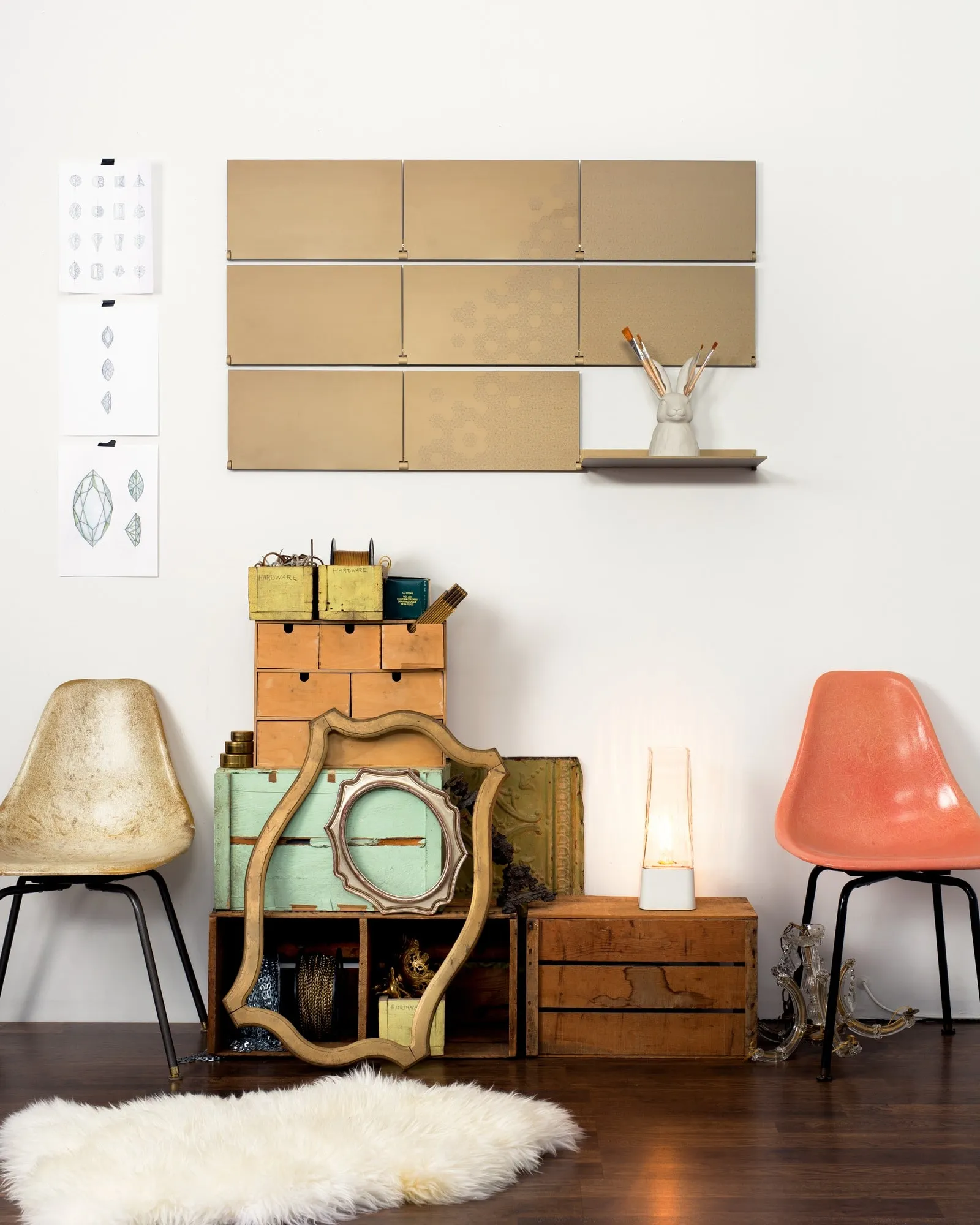 Riveli Luxe Shelves in Aged Bronze with a laser-etched pattern above vintage chairs and crates