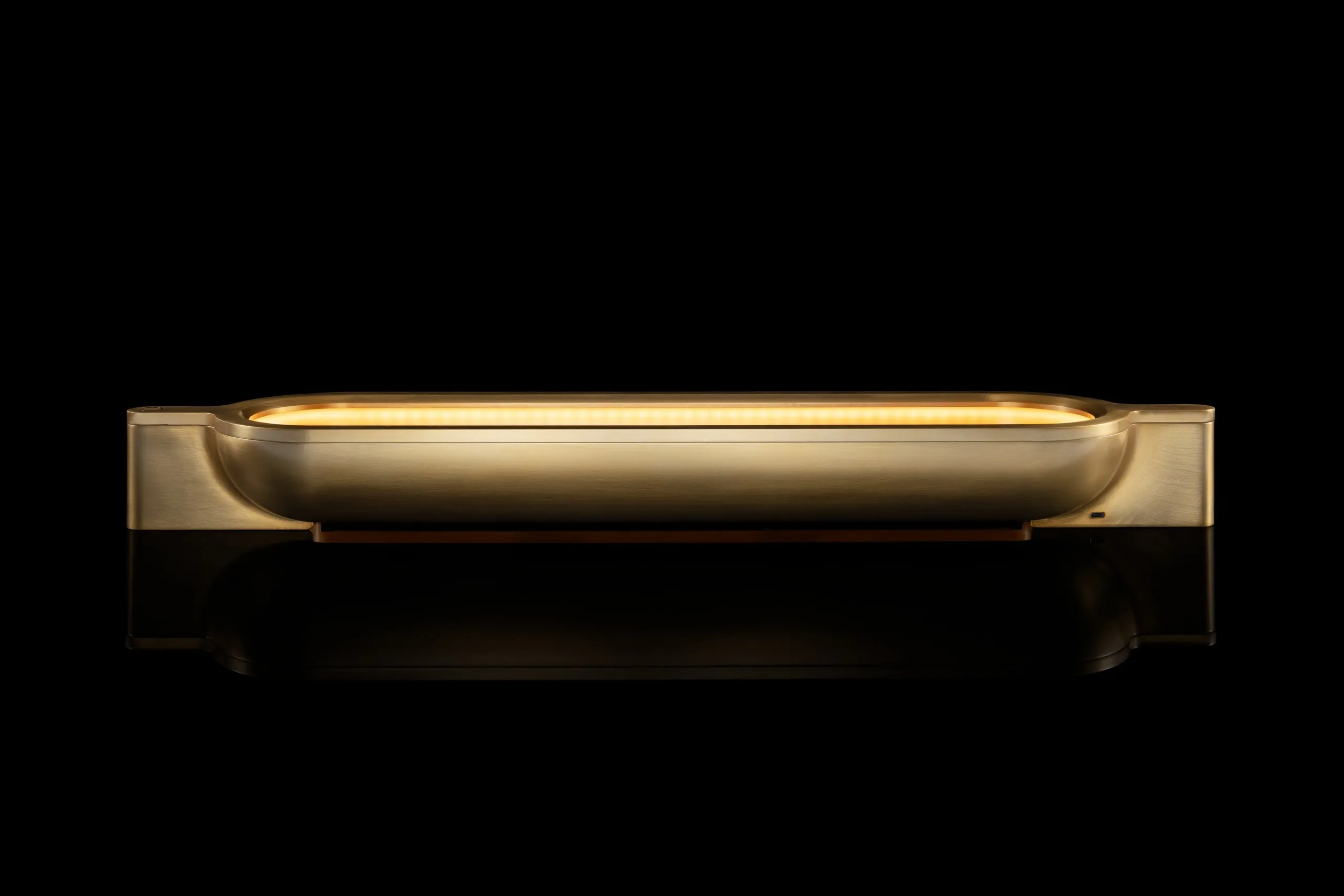 A Vessel Lamp in brass, lit, against black