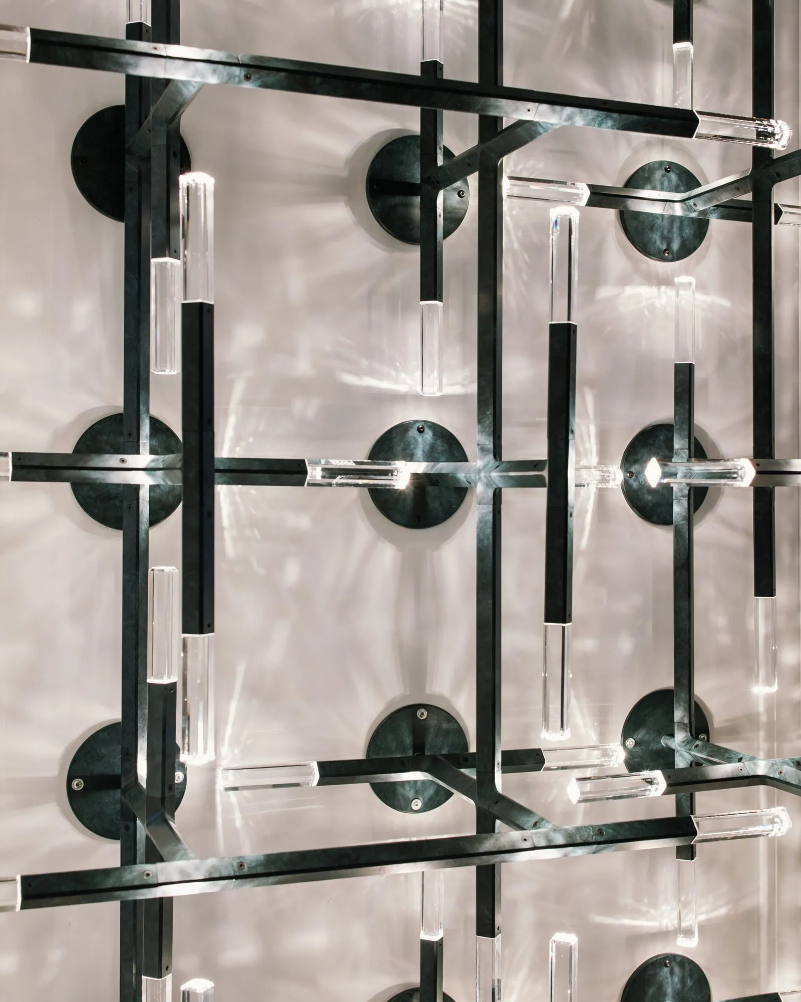A JAX screen of black arms and crystals before a reflective wall, close up