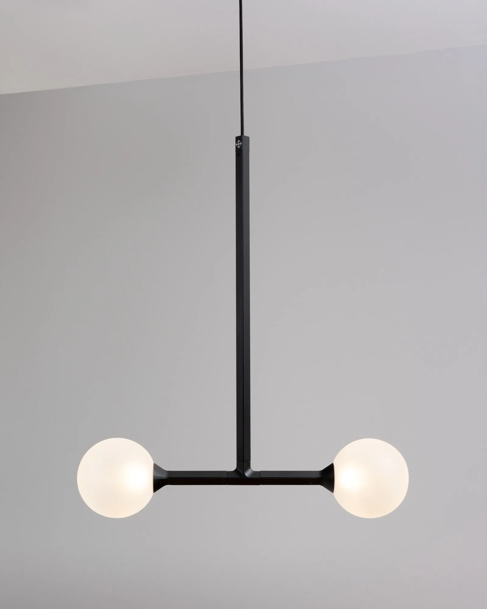 A JUNIP pendant: one stem ending in a crossbar with a globe at each end