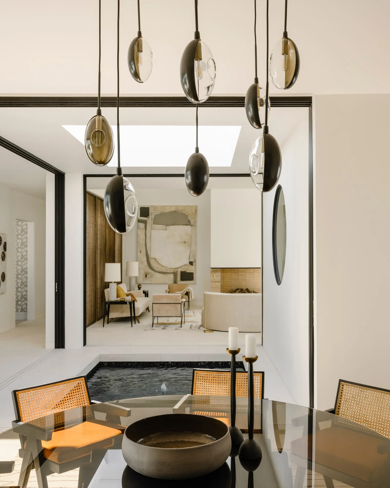 Oona pendants at staggered heights beside a courtyard window, a dining room beyond